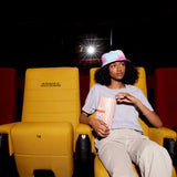 Woman wearing tie dye hat and grey TIFF t-shirt in cinema