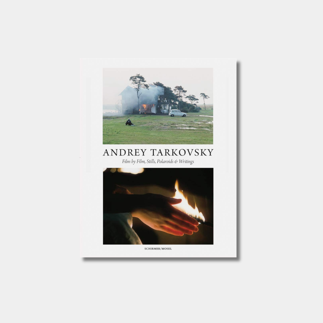 Book cover featuring a landscape with a house and a person, and a close-up of hands holding a flame.