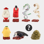 Seven small figurines of various spirits and creatures from the movie Spirited Away are arranged against a plain gray background, with a black circle containing a white question mark representing a hidden "mystery" figure in the se