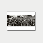A panoramic black-and-white photograph spread across a two-page book layout captures a dense, chaotic crowd of reporters, photographers holding video cameras, and onlookers gathered outside a building in a city square.