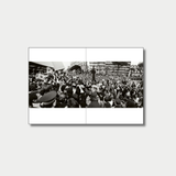A panoramic black-and-white photograph spread across a two-page book layout captures a dense, chaotic crowd of reporters, photographers holding video cameras, and onlookers gathered outside a building in a city square.