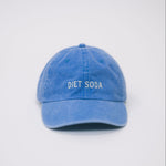 Front view of a blue baseball cap on a white background, featuring “Diet Soda” embroidered in white on the front.