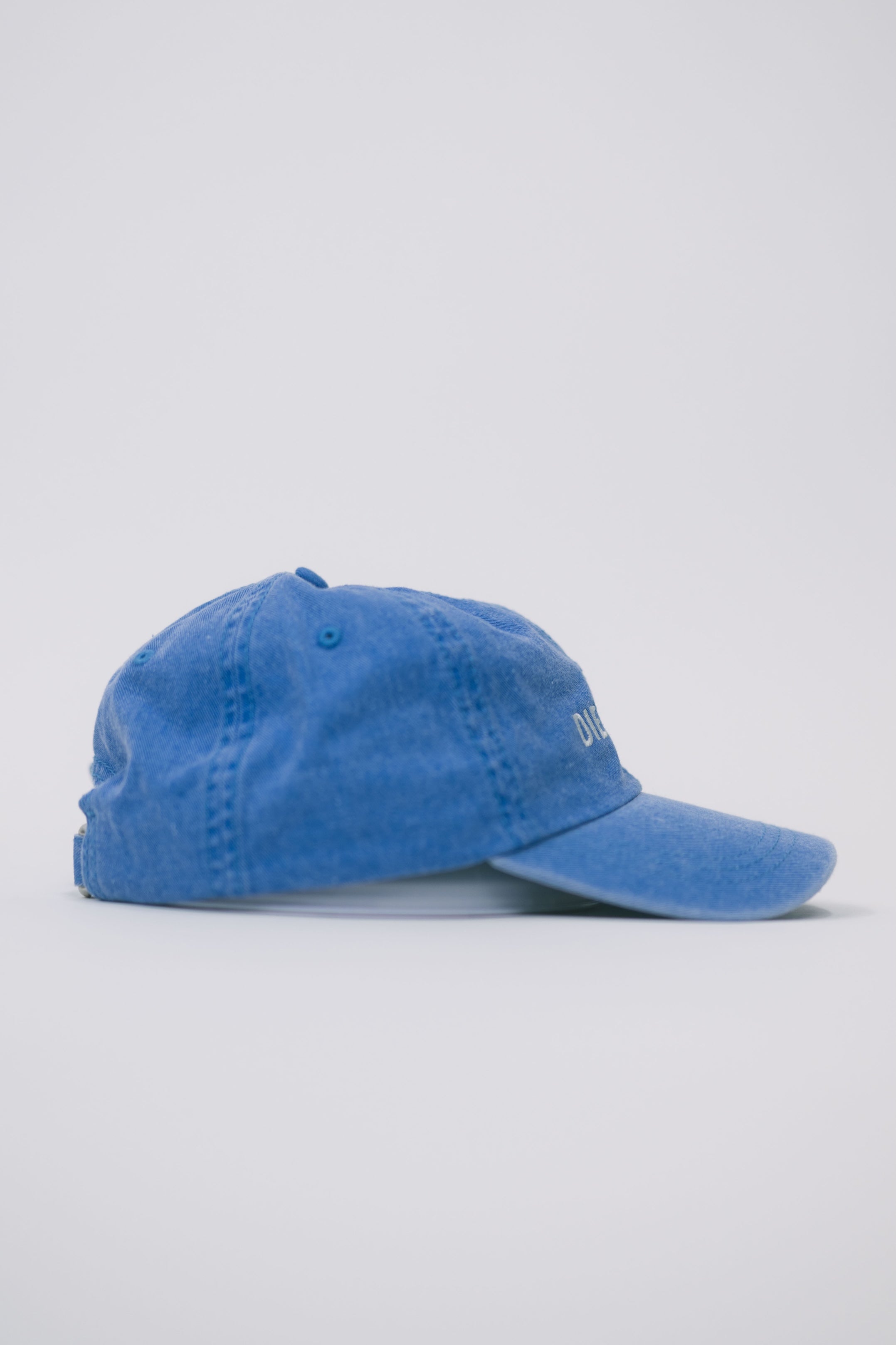 Side view of a blue baseball cap on a white background.