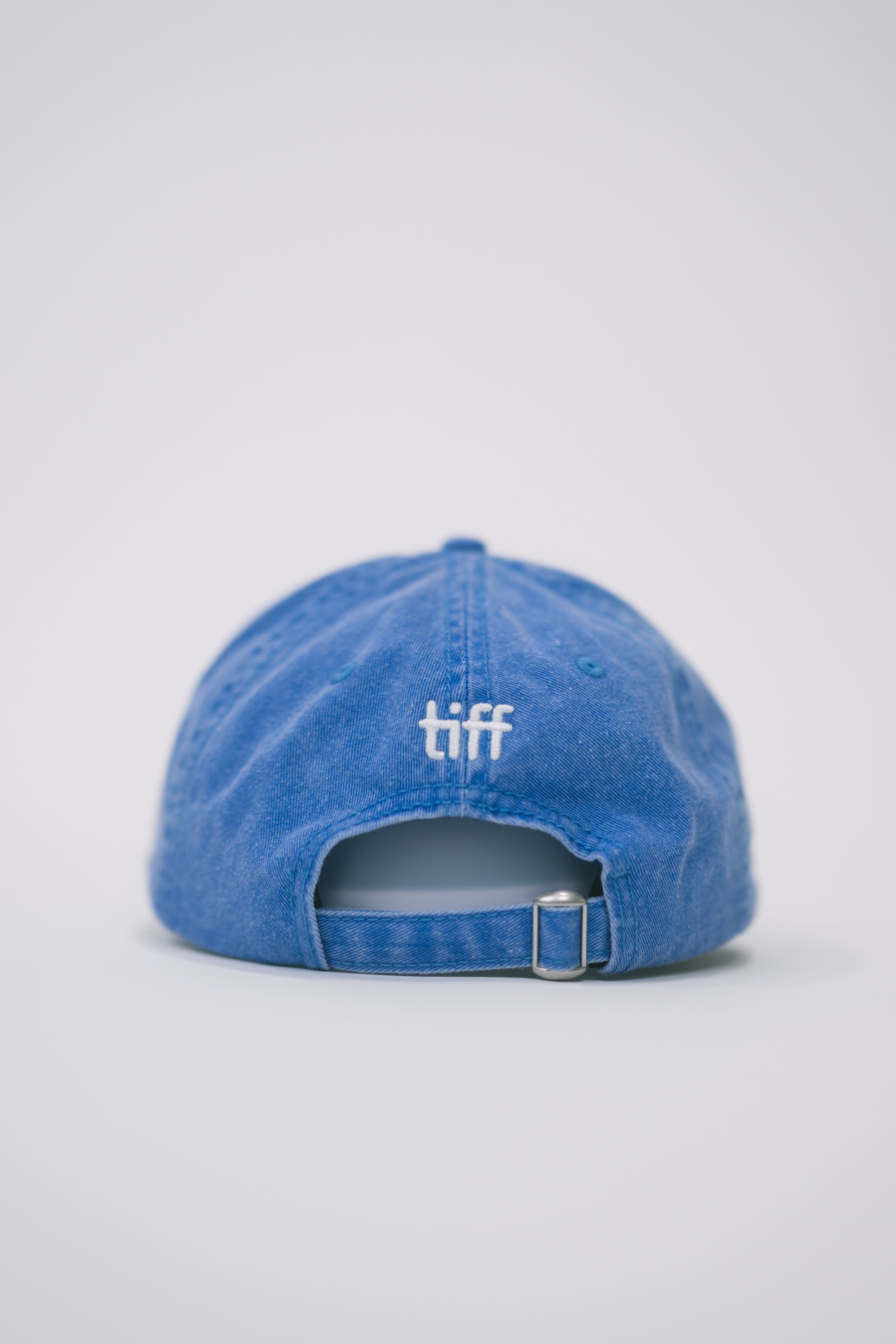 Back view of a blue baseball cap on a white background, featuring white “TIFF” embroidery on the back.
