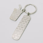 Silver-tone keychain on a white background featuring back of two "TIFF" embossed charms.
