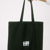 Black tote bag with 'tiff' logo held by a hand on a white background