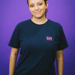 Person wearing a black t-shirt with 'tiff' logo on a purple background