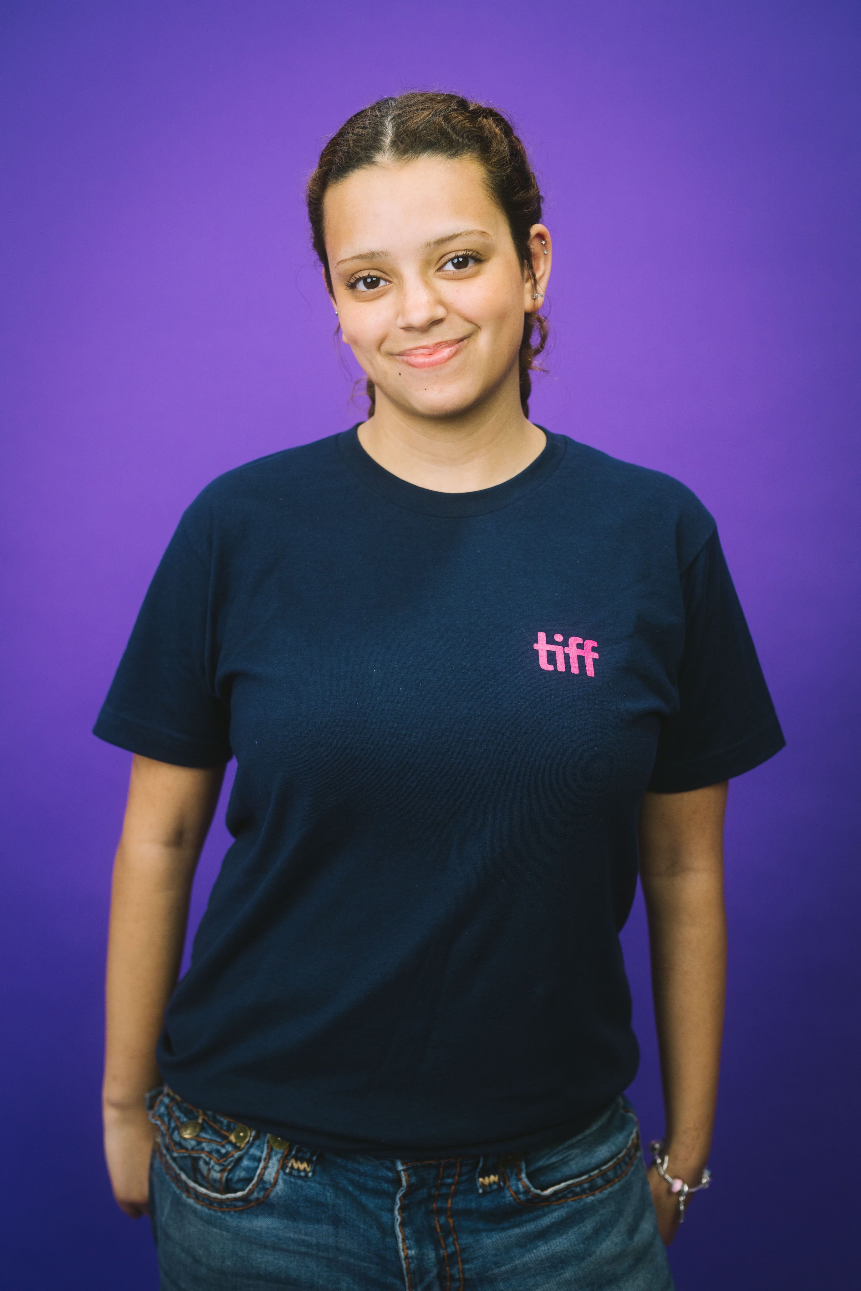 Person wearing a black t-shirt with 'tiff' logo on a purple background