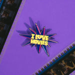 Star-shaped pin with 'I Love Movies' text on a purple background with filmstrip