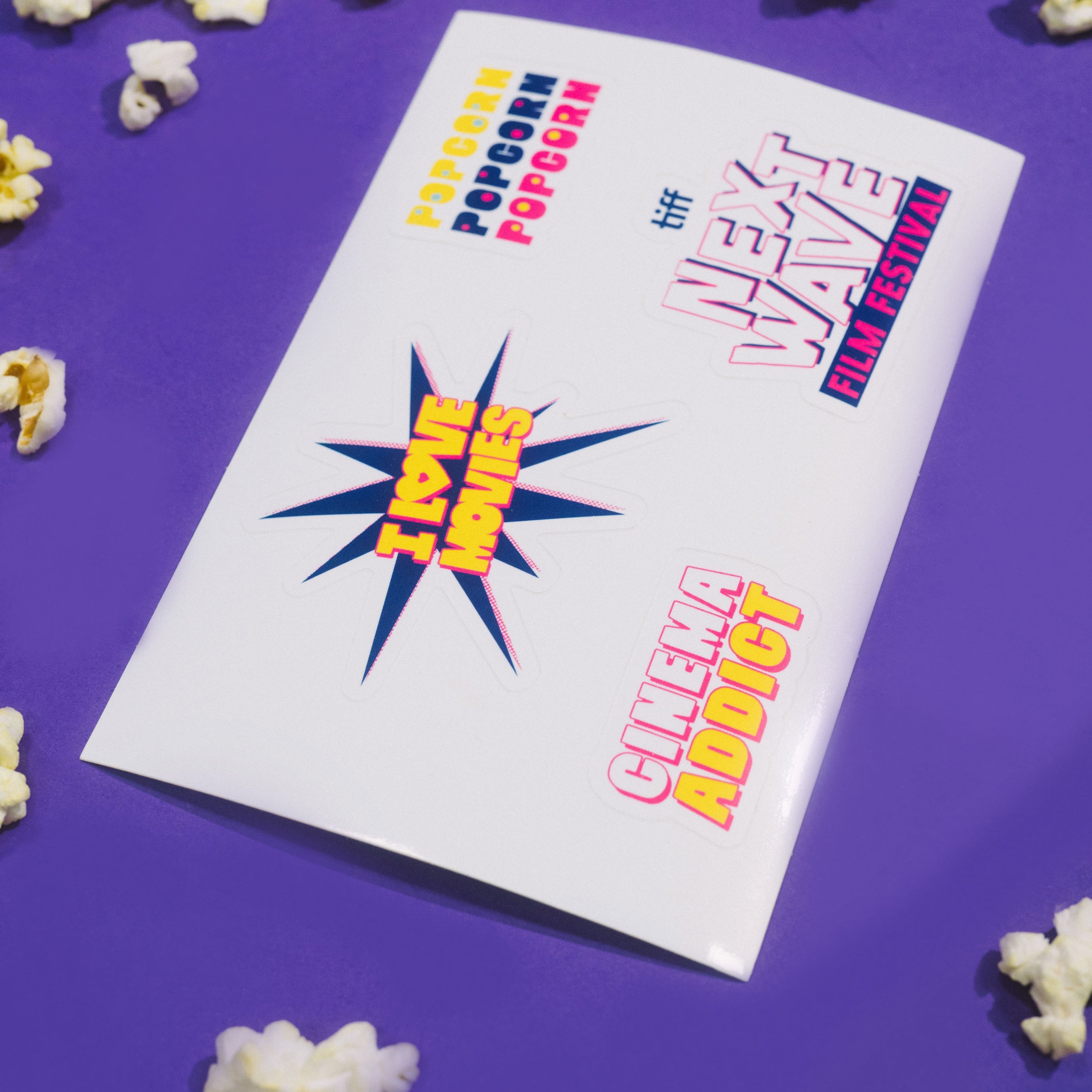 Popcorn and a card with movie festival text on a purple background