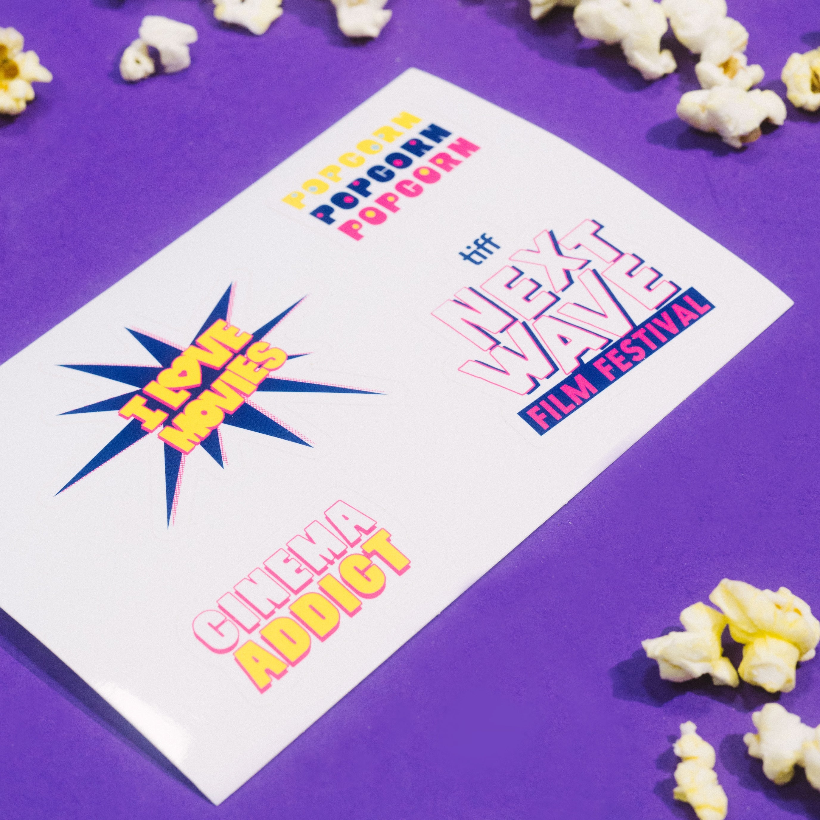 Popcorn and a card with movie festival text on a purple background