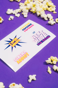 Popcorn and a card with movie festival text on a purple background