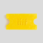 A bright yellow wax melt or soap bar shaped like a movie ticket, embossed with the word 'tiff' in the center, on a solid light gray background.