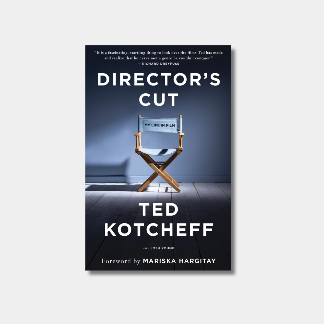 The book cover for "Director's Cut" features bold white and blue text set against a cinematic background showing a lone director's chair illuminated by a dramatic spotlight on a dark wooden floor.