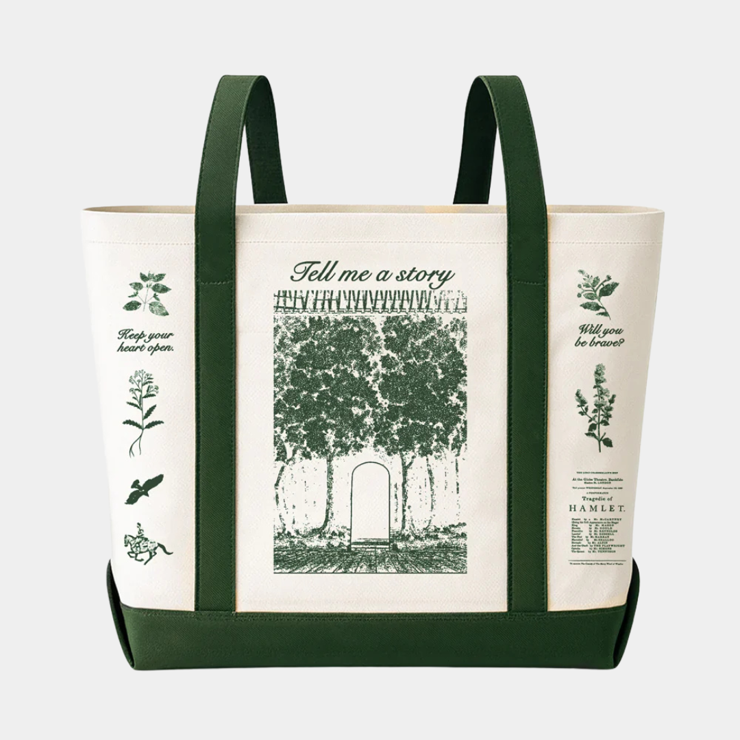 A canvas tote bag featuring dark green straps and base with a cream-colored body adorned with green botanical illustrations, literary quotes, and a central image of a garden gate.