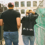 Two people walking on a city street with a construction site in the background