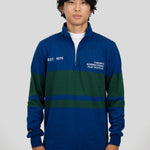 A model wears a blue and dark green quarter-zip pullover featuring "EST. 1976" and "TORONTO INTERNATIONAL FILM FESTIVAL" printed on the chest.