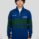 A model wears a blue and dark green quarter-zip pullover featuring "EST. 1976" and "TORONTO INTERNATIONAL FILM FESTIVAL" printed on the chest.