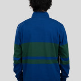 Back of model wearing a blue and dark green quarter-zip pullover.