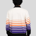 Back of model wearing a long-sleeved, collared rugby shirt featuring orange, purple, and black stripes.