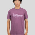 A man wearing a heathered purple t-shirt with a white graphic print that reads 'Toronto International Film Festival' on the chest, standing against a solid gray background.