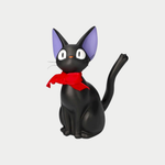 A black cat figurine representing Jiji from Kiki's Delivery Service sits upright with large eyes, purple inner ears, and a prominent red bow tied around its neck.
