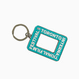 A teal rectangular enamel keychain featuring the Toronto International Film Festival logo and a cutout center resembling a camera viewfinder.
