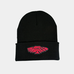 A black ribbed knit beanie featuring a centered, pink embroidered patch with stylized "Midnight Madness" text in a warped, circular graphic.