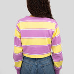 Back of model wearing a long-sleeved cropped shirt featuring yellow, purple, and white stripes.