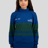 A model wears a blue and dark green quarter-zip pullover featuring "EST. 1976" and "TORONTO INTERNATIONAL FILM FESTIVAL" printed on the chest.