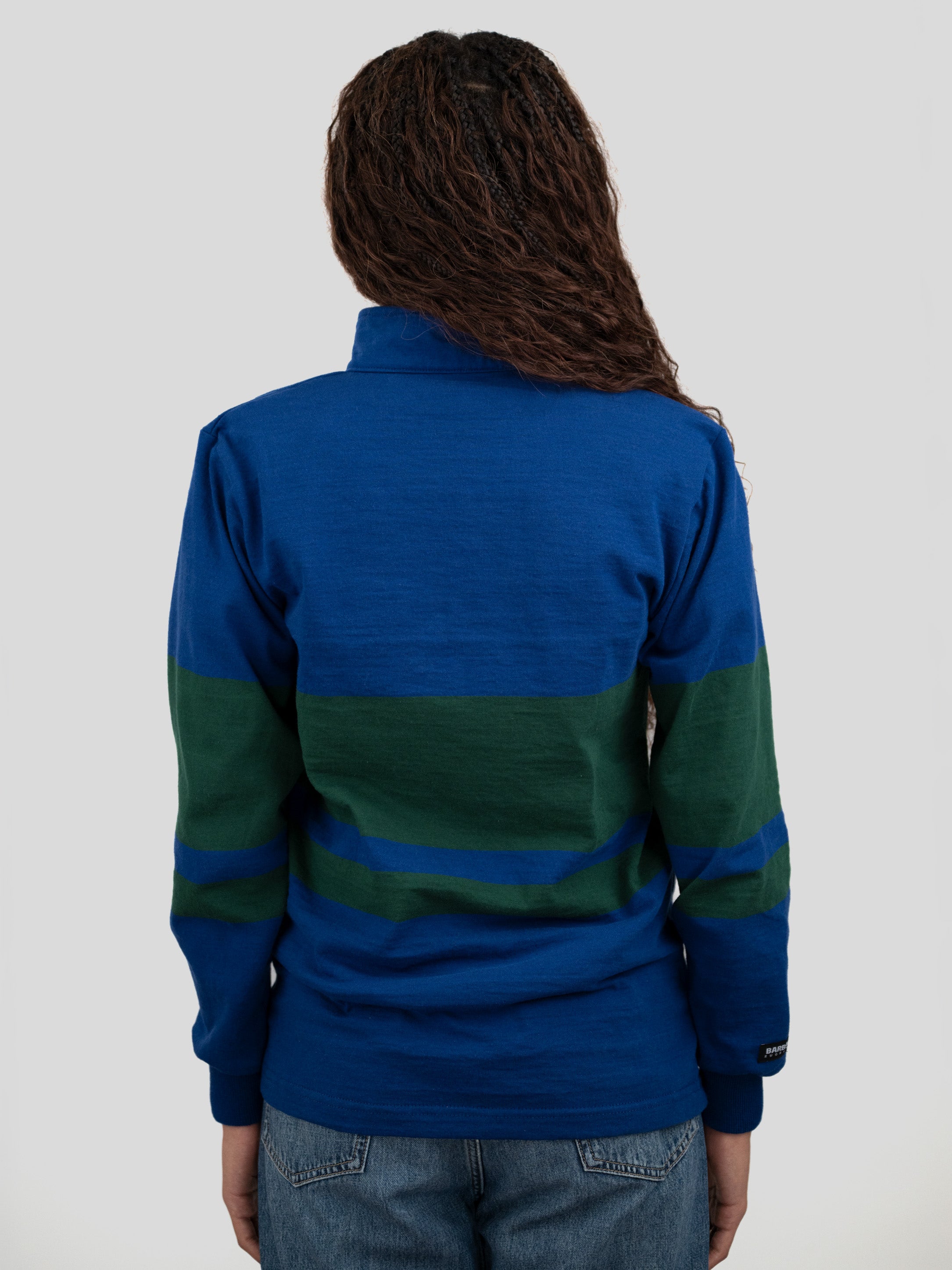 Back of model wearing a blue and dark green quarter-zip pullover.