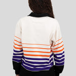 Back of model wearing a long-sleeved, collared rugby shirt featuring orange, purple, and black stripes.