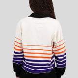 Back of model wearing a long-sleeved, collared rugby shirt featuring orange, purple, and black stripes.