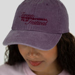 A person wearing a washed purple baseball cap with embroidered text reading 'Toronto International Film Festival' in dark red, shown against a light gray background.