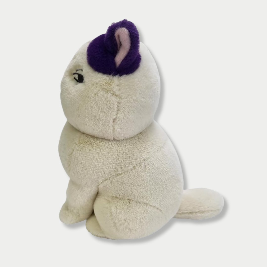 Side view of off-white cat plush toy with a distinct purple patch on its left ear, featuring half-lidded, cynical eyes and a small embroidered mouth against a plain light background.


