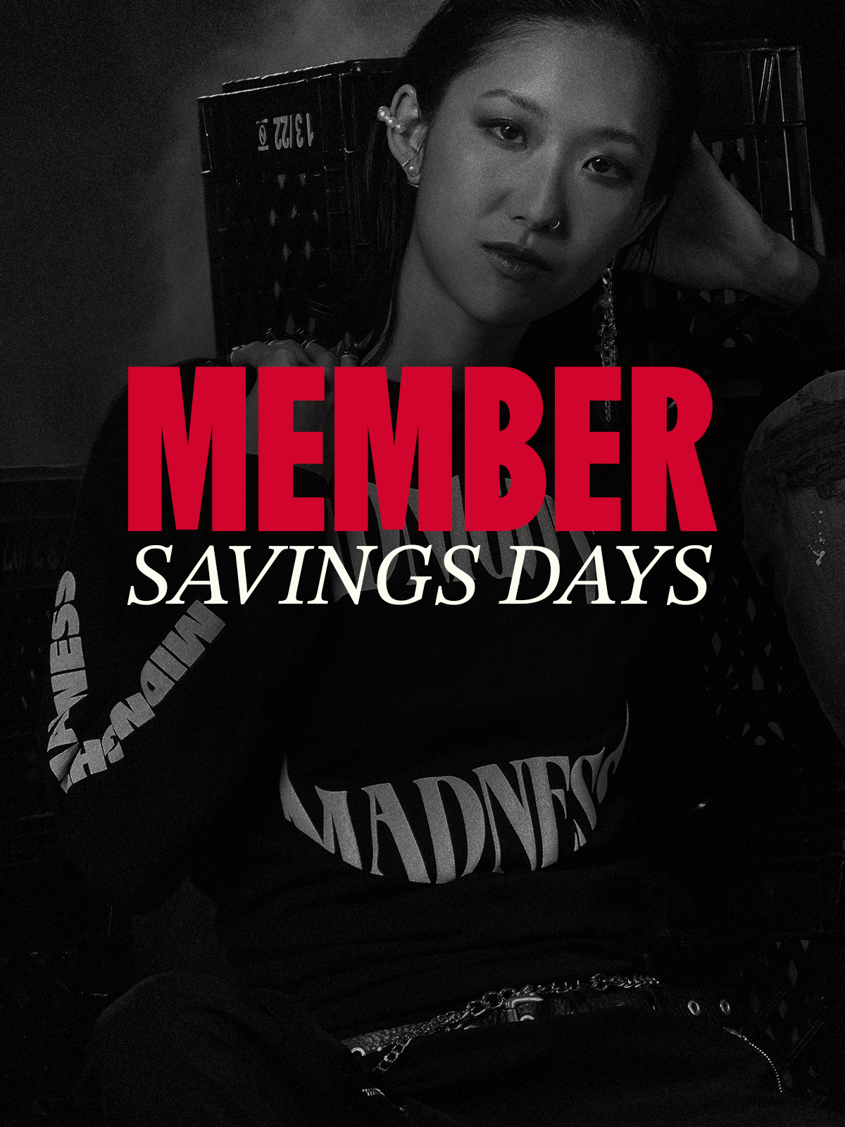 Black and white photo of a person with chain earrings and hand on shoulder wearing longsleeve shirt with the word 'Midnight Madness' on chest. 'MEMBERS Savings Days' red and white text at centre.