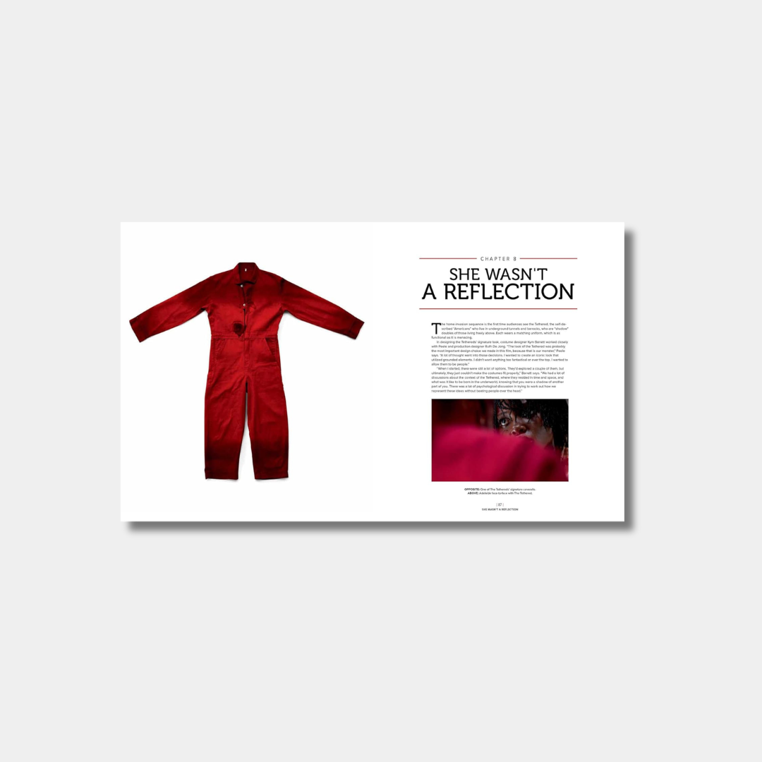 An open book spread shows a red jumpsuit on the left page and the title "Chapter 8: SHE WASN'T A REFLECTION" above a film still of a character on the right page.
