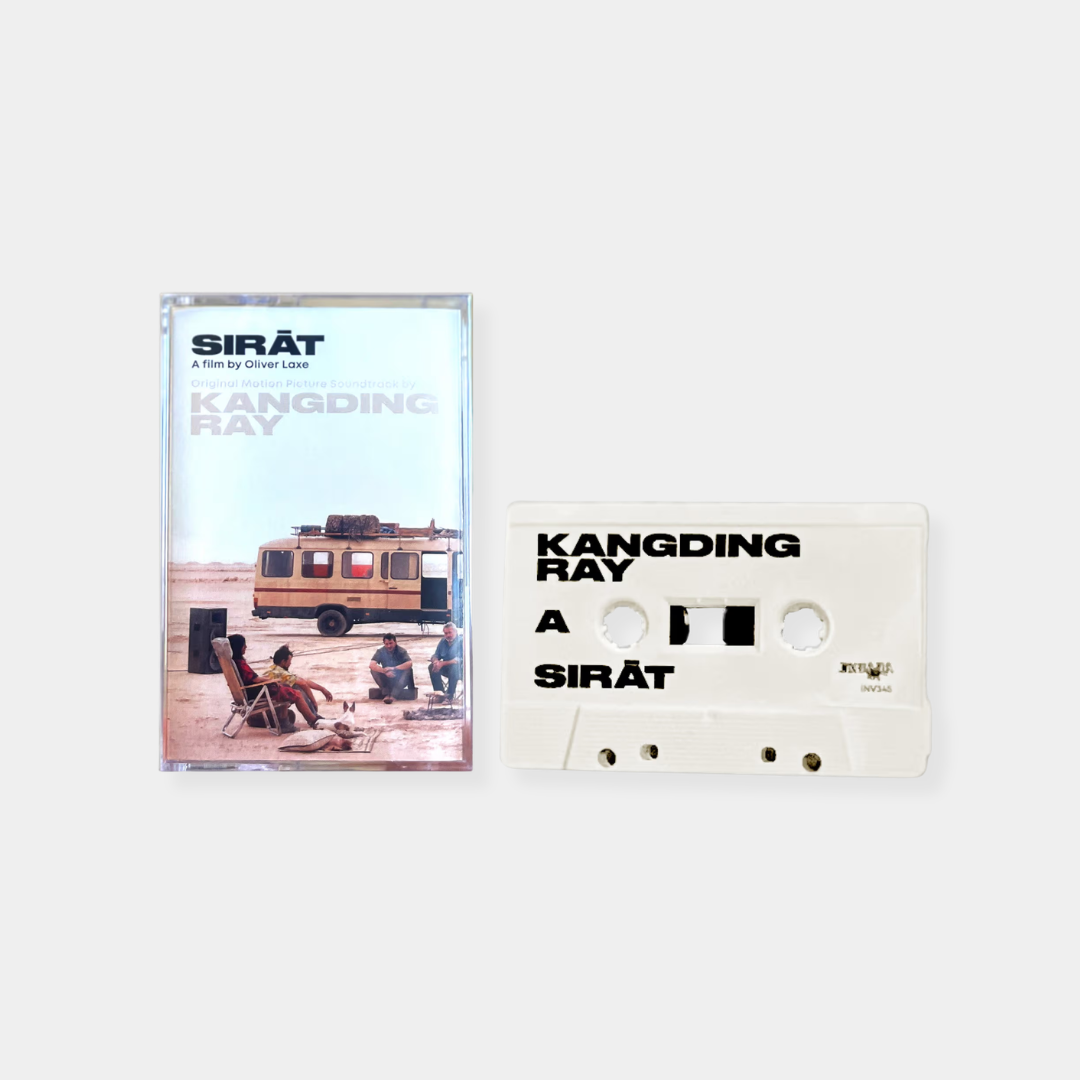 A white cassette tape and its J-card case for the original motion picture soundtrack of the film SIRĀT by Oliver Laxe, featuring music by Kangding Ray, set against a plain gray background.