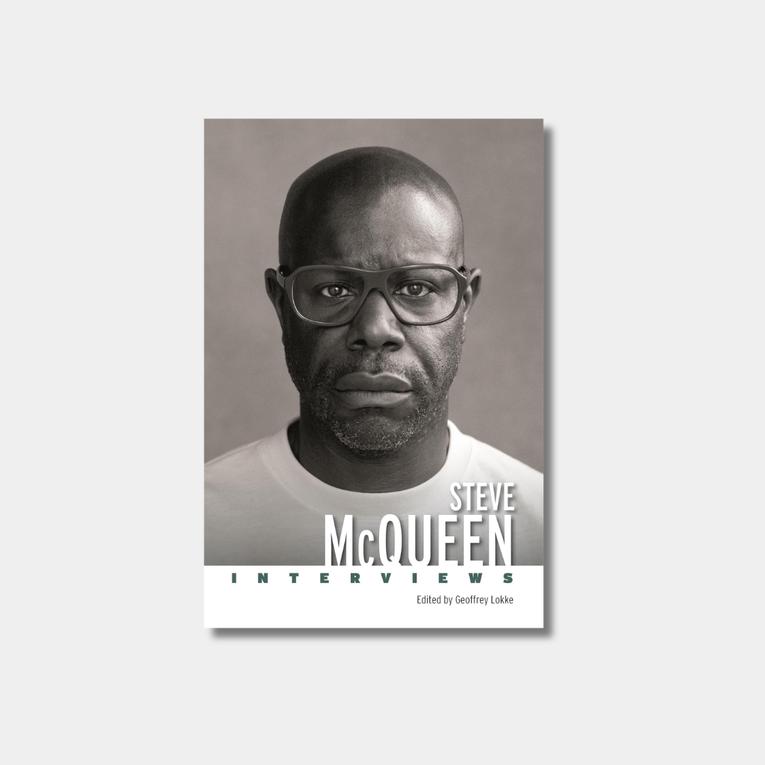 A black-and-white portrait of director Steve McQueen wearing glasses on with "Steve McQueen: Interviews" in white text.