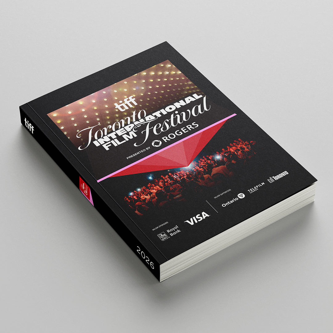 A high-angle studio mock-up showcases a thick, black-covered 2026 Toronto International Film Festival programme book featuring stylized festival typography, sponsor logos, and a red geometric design depicting a crowd.