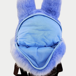 Open light blue Totoro-shaped backpack featuring large embroidered eyes, a white belly with crescent markings, adjustable brown straps, and an open zippered main compartment.