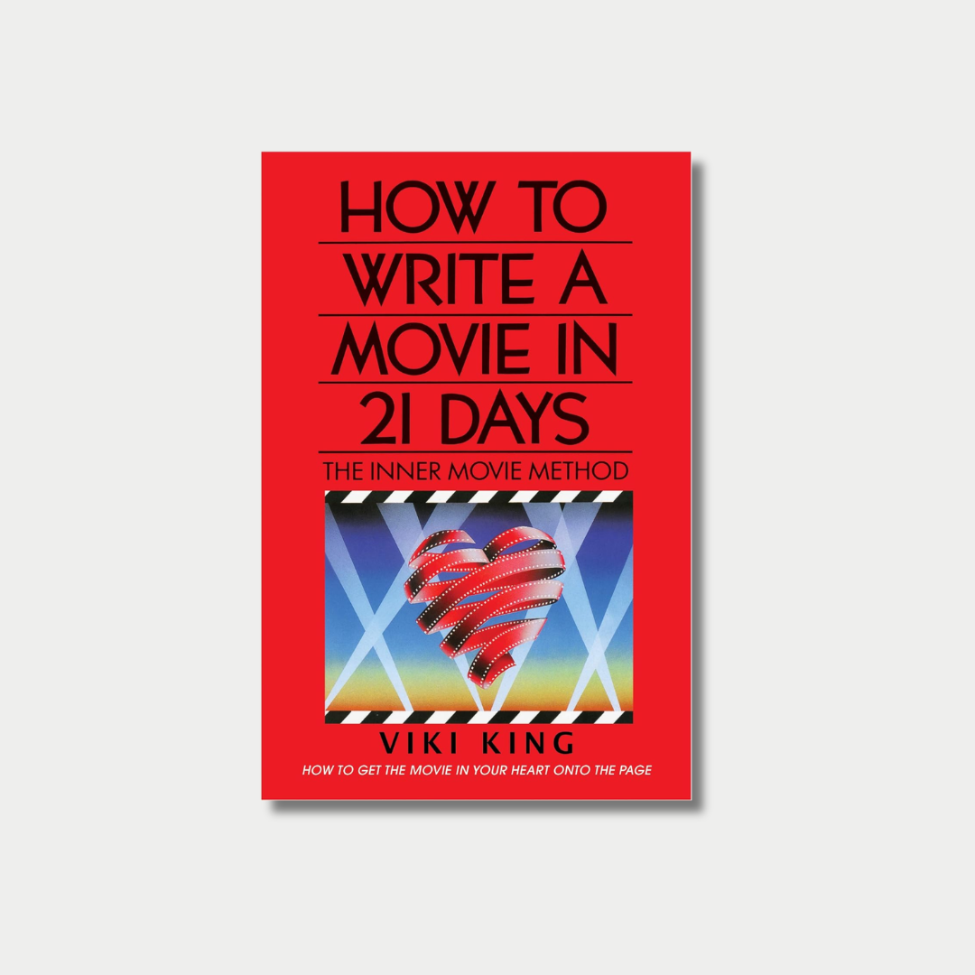 The image features the vibrant red book cover of "How to Write a Movie in 21 Days: The Inner Movie Method" by Viki King, which displays the title in bold black text separated by horizontal lines above a retro illustration of a film strip shaped like a heart under spotlights.