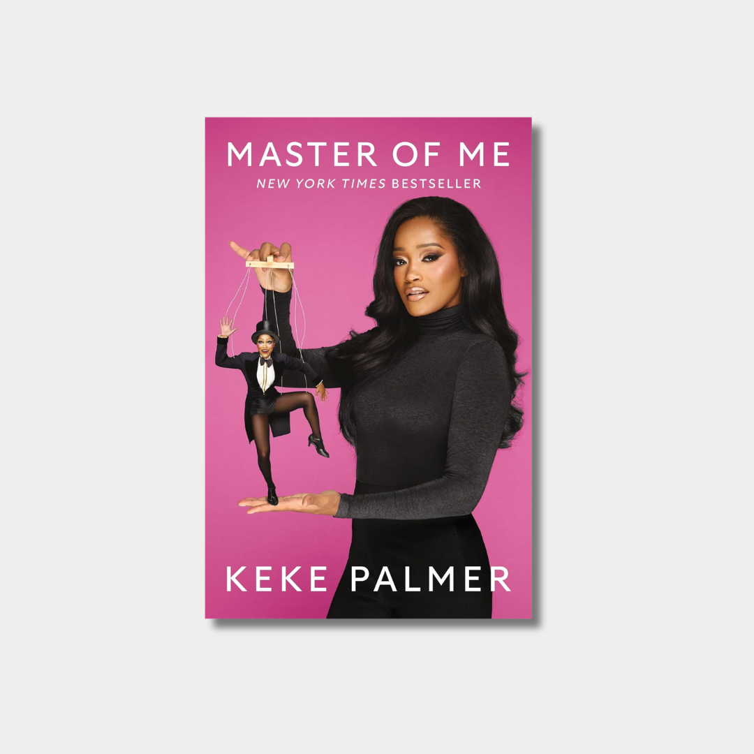Book cover of "Master of Me" by Keke Palmer, featuring Keke Palmer wearing a black turtleneck against a bright pink background while holding a puppet version of herself dressed in a tuxedo and top hat.