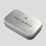 A rectangular silver metal tin with rounded corners, featuring the words 'ready for my close-up' and 'tiff' printed on the lid, set against a solid light gray background.