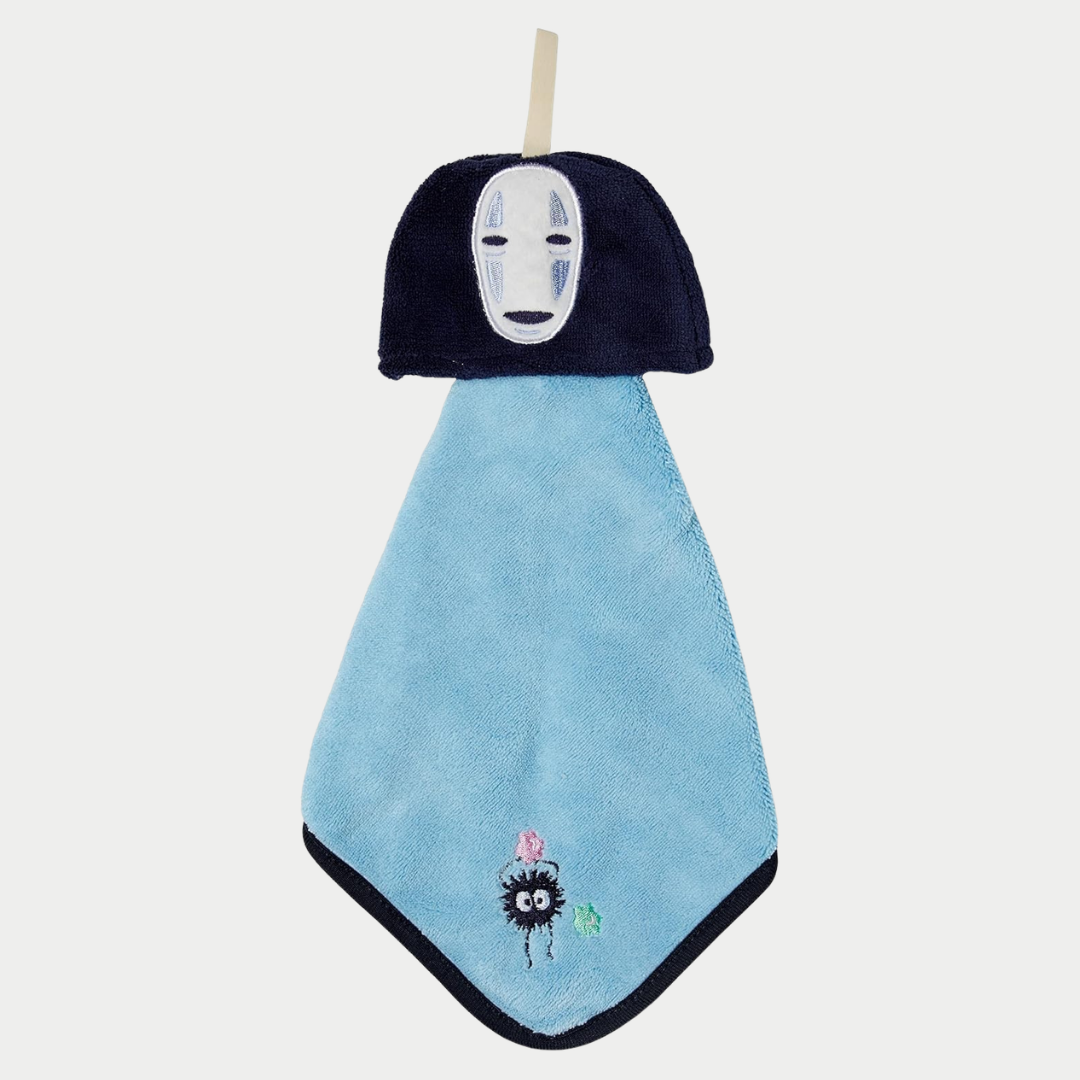 A blue hanging hand towel features the face of No-Face from Spirited Away at the top and an embroidered soot sprite near the bottom corner.
