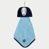 A blue hanging hand towel features the face of No-Face from Spirited Away at the top and an embroidered soot sprite near the bottom corner.
