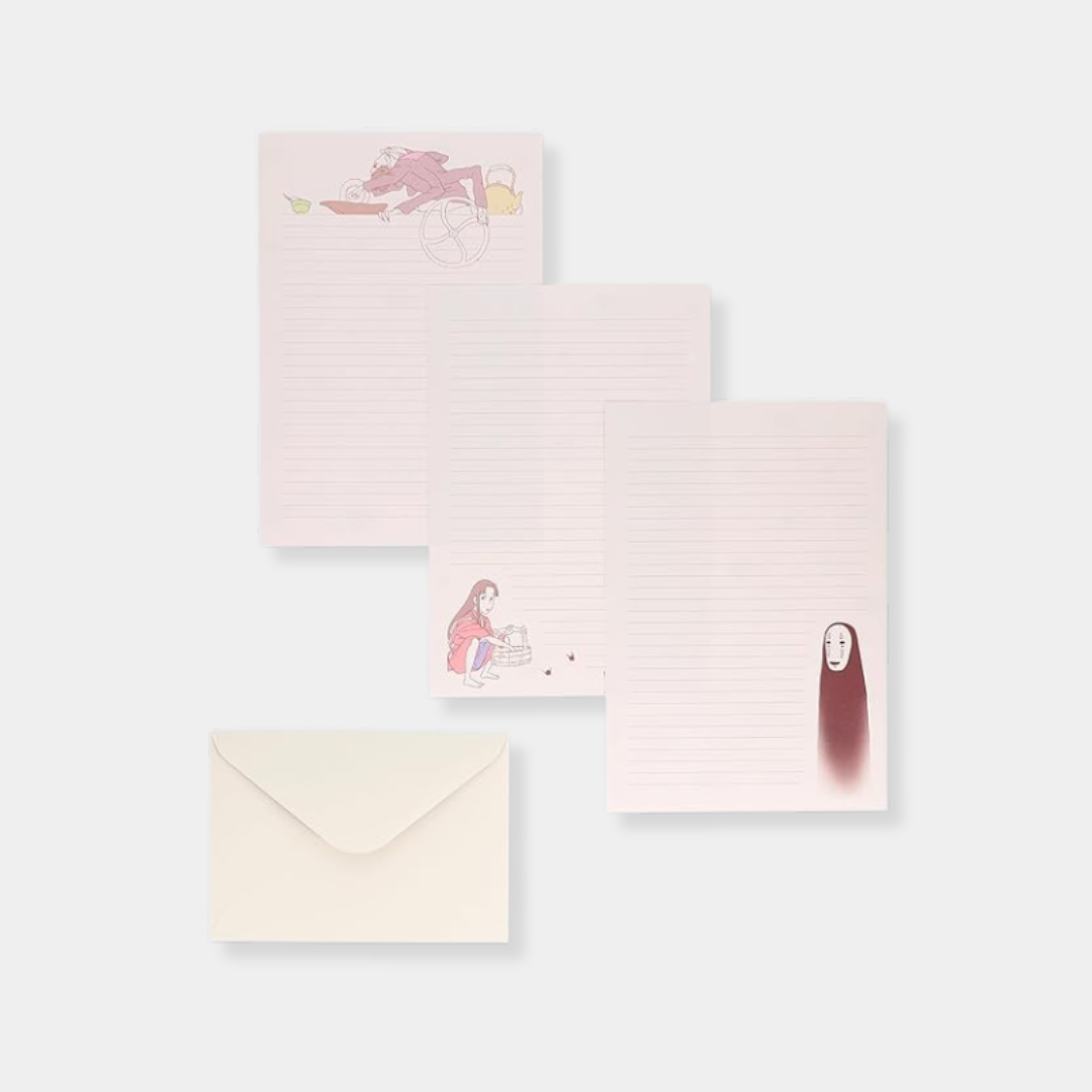 Three sheets of light pink lined stationary from a "Spirited Away" set feature illustrations of Kamajī, Chihiro, and No-Face, displayed alongside a plain cream-colored envelope.