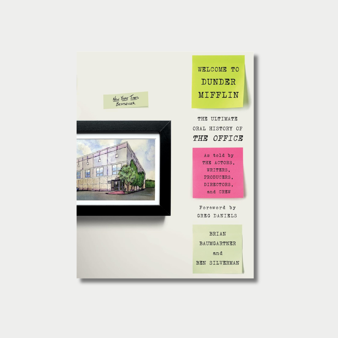 The image displays the book cover of 'Welcome to Dunder Mifflin: The Ultimate Oral History of The Office" by Brian Baumgartner and Ben Silverman, featuring a framed watercolor illustration of the show's office building alongside simulated sticky notes containing the title, authors, and book details.