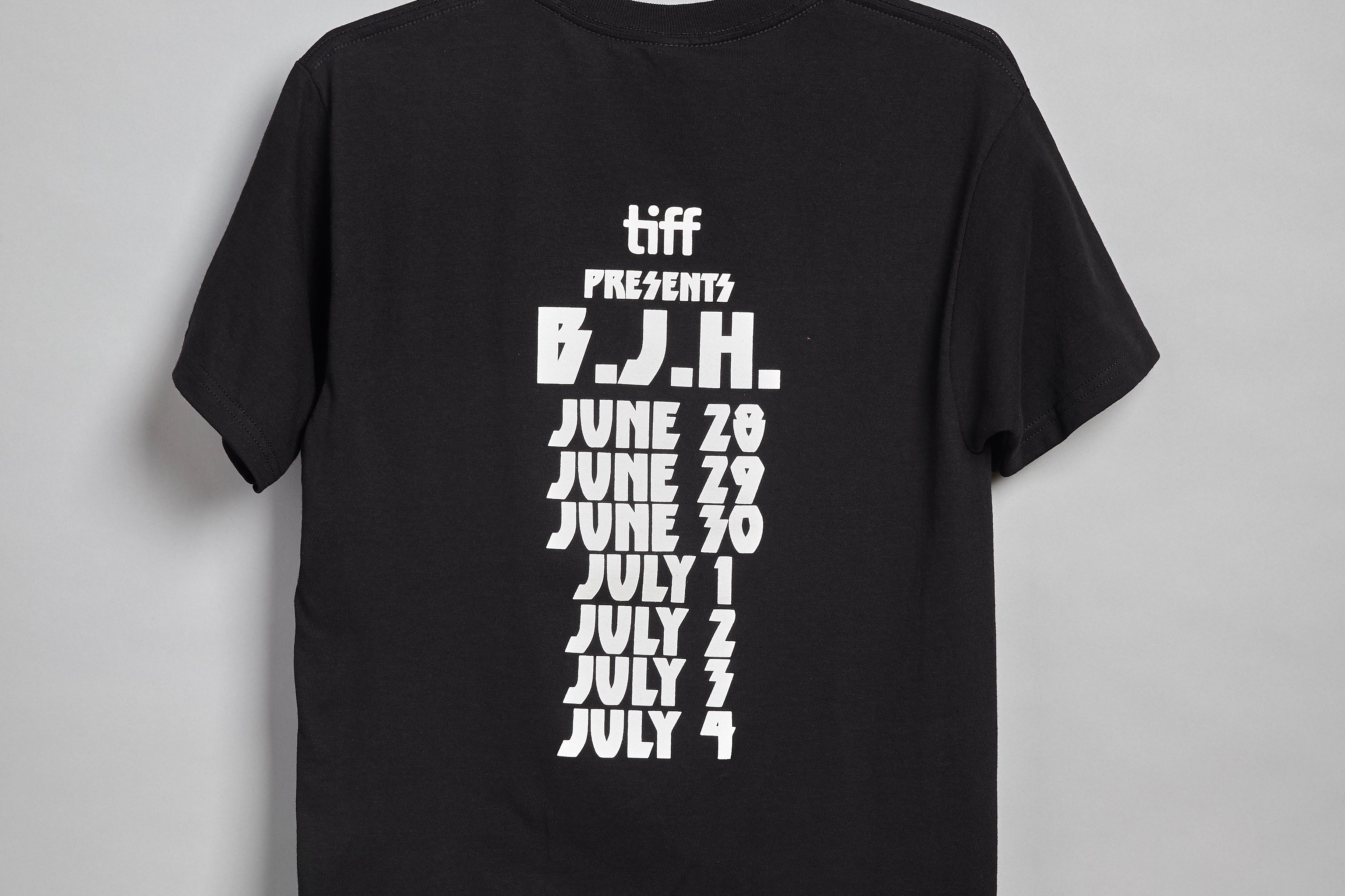 Black T-Shirt with a white "Heavy Metal" style type face on the back. Mimicking dates that are usually written on the back of a concert tour T-Shirt. It reads, "tiff presents B.J.H. June 20, June 29, June 30, July 1, July 2, July 4"