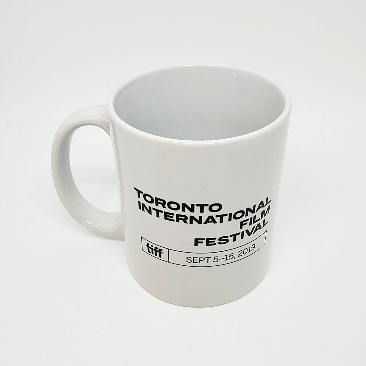 Reverse side of white mug with "Toronto International Film Festival, September 5-15, 2019" written in black